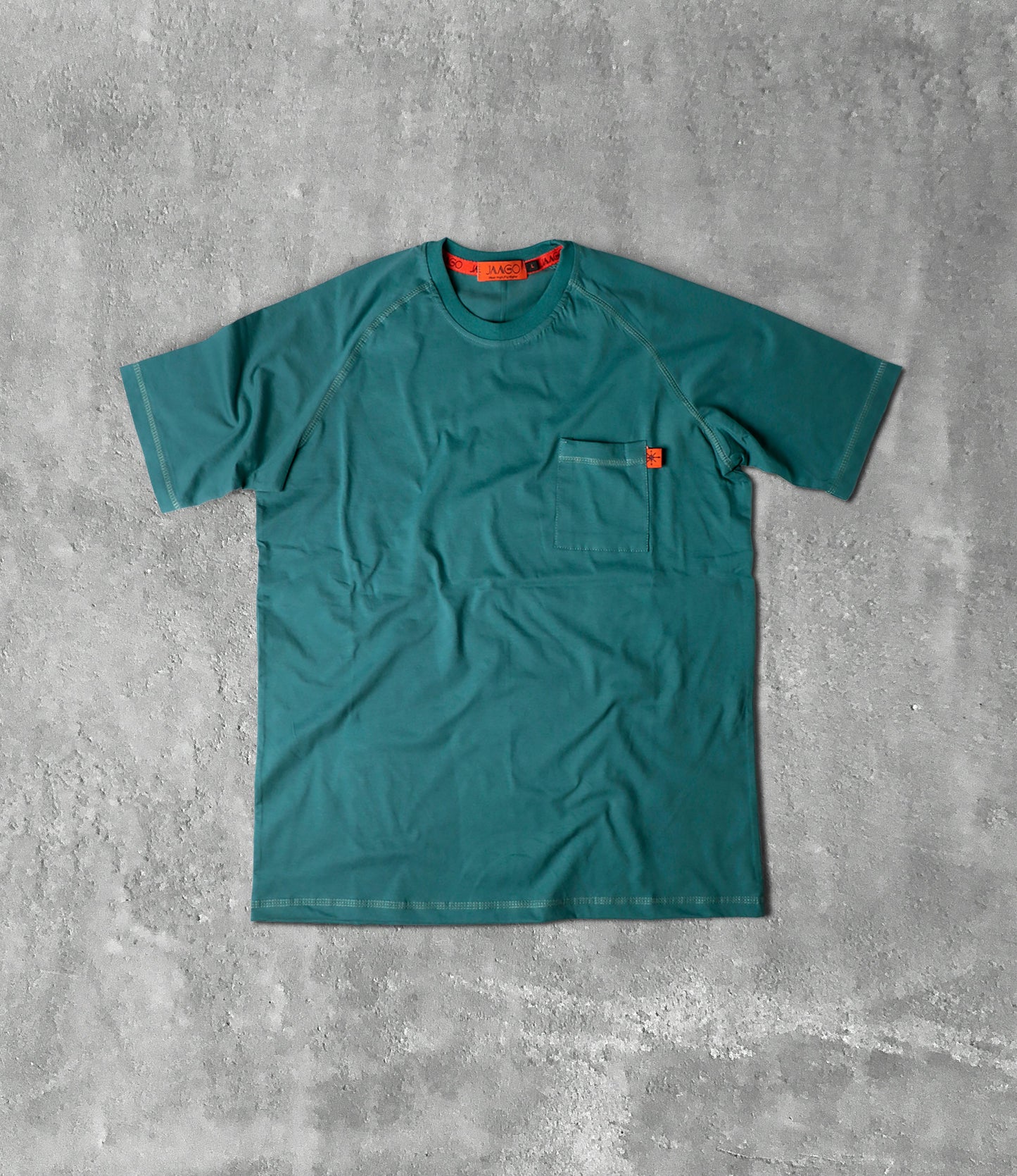 T-shirt vert posé sur un sol en béton