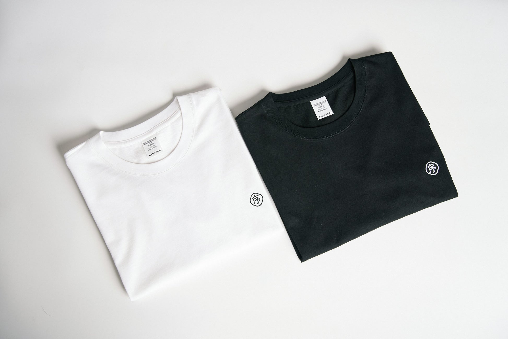 Deux t-shirts noir et blanc posés côte à côte