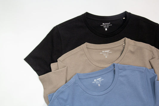 Trois t-shirts pliés côte à côte de couleurs différentes